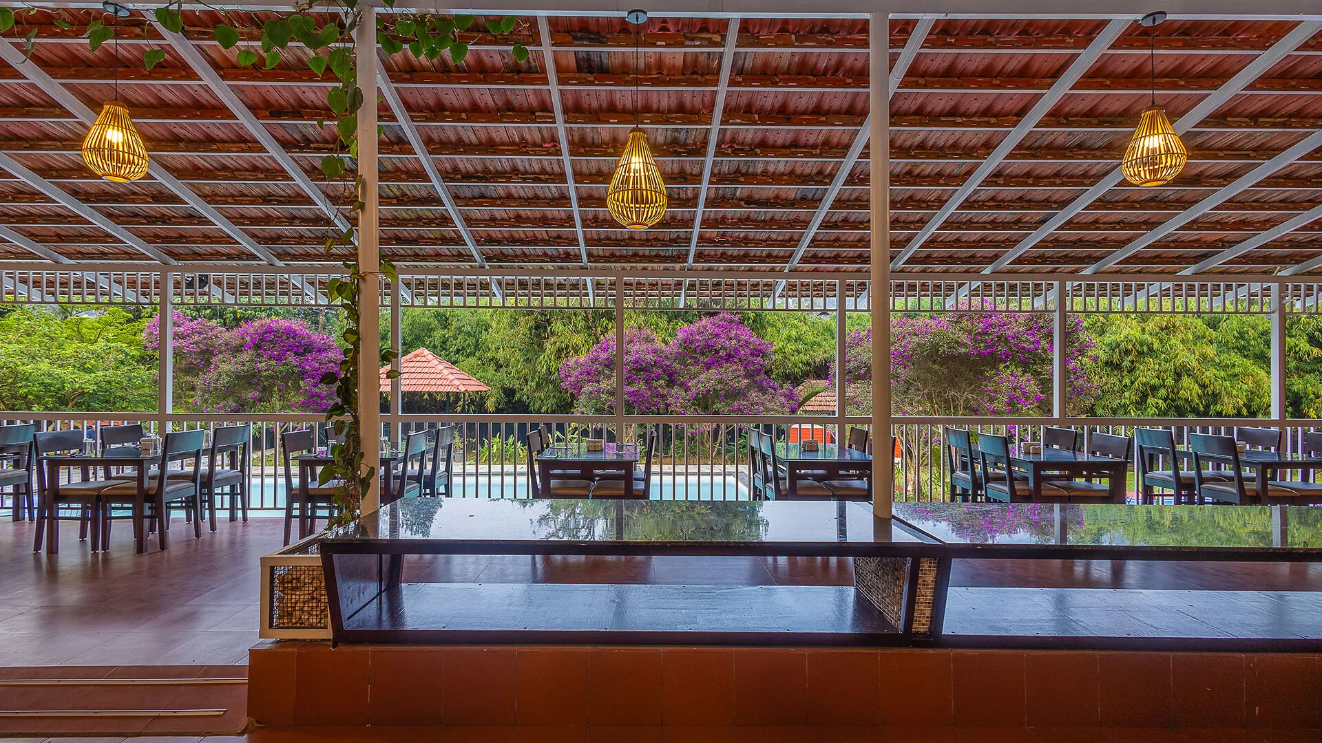 Wide view of the open-air restaurant terrace and buffet counter at Karma Vythiri
