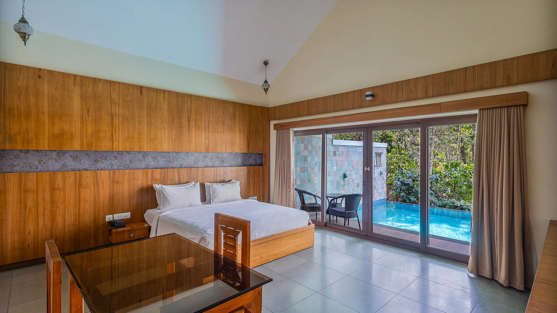 Bedroom with wood paneling and private pool view at Karma Vythiri