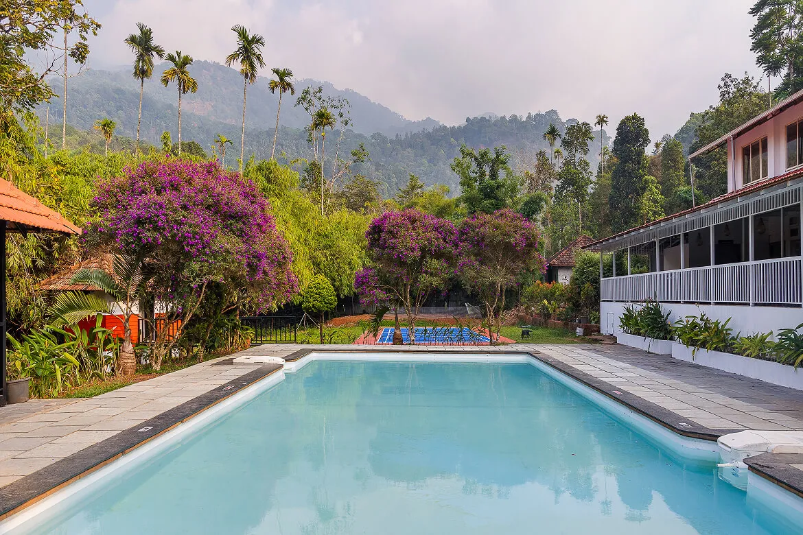 Swimming pool with panoramic Western Ghats mountain views at Karma Vythiri, Wayanad