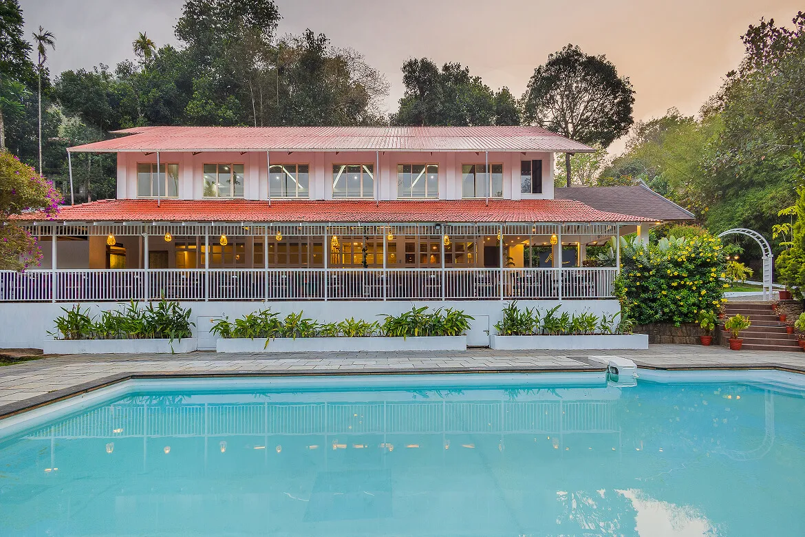 Evening view of the Karma Vythiri resort building from the poolside