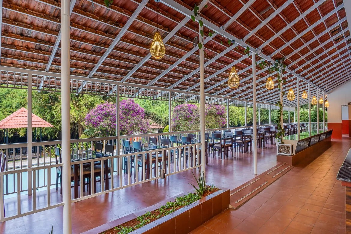Open-air dining terrace with garden views at Karma Vythiri restaurant, Wayanad