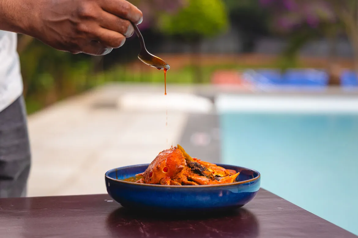 Chef plating crab curry poolside at Karma Vythiri restaurant, Wayanad