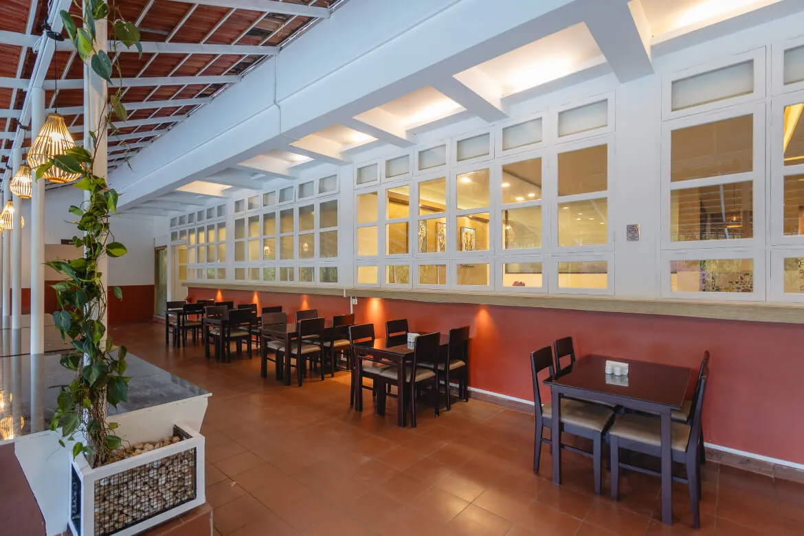 Indoor dining hall with large windows at Karma Vythiri restaurant