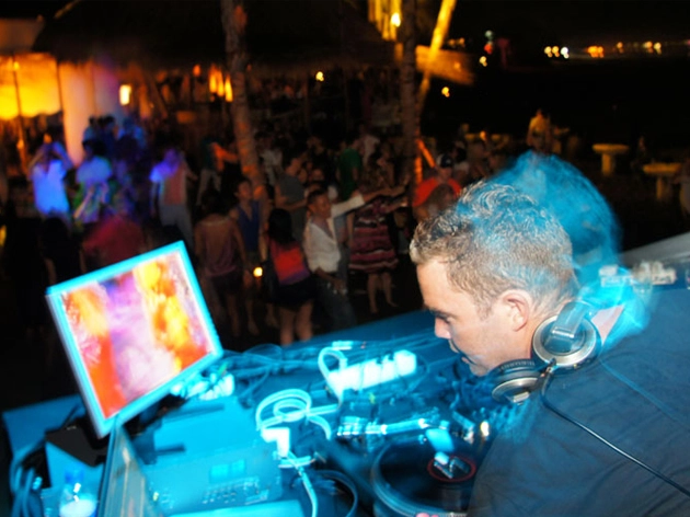 DJ performing for a crowd at a Karma Beach club party