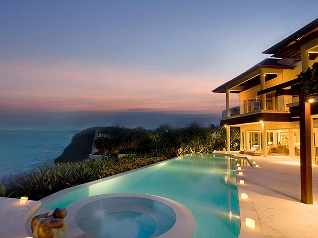 Cliffside infinity pool and villa at dusk, a Karma Resorts property