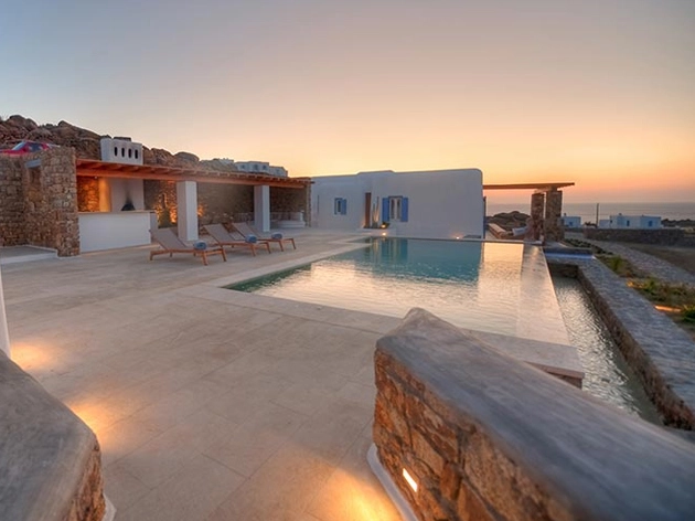 Infinity pool and whitewashed villa terrace at sunset, a Karma Estates property