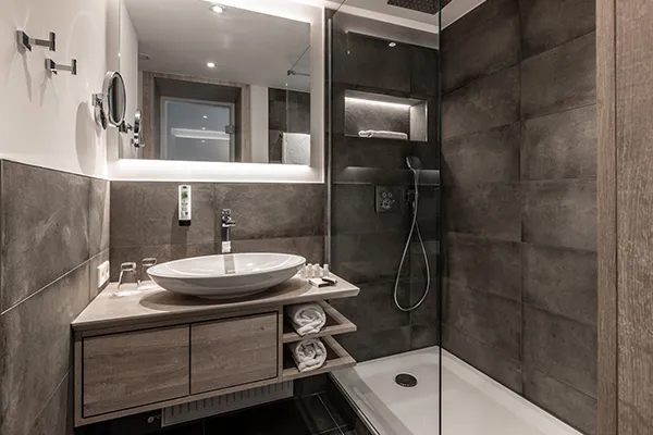 En-suite bathroom with rainfall shower at Karma Bavaria, a luxury resort in Schliersee