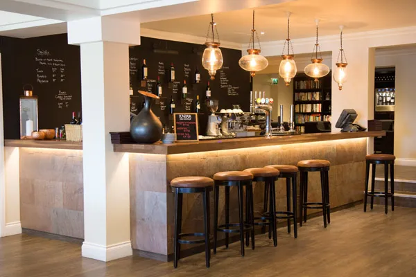Bar & Wine Lounge at Karma St. Martin's with a stone-clad bar, leather stools and glass pendant lights