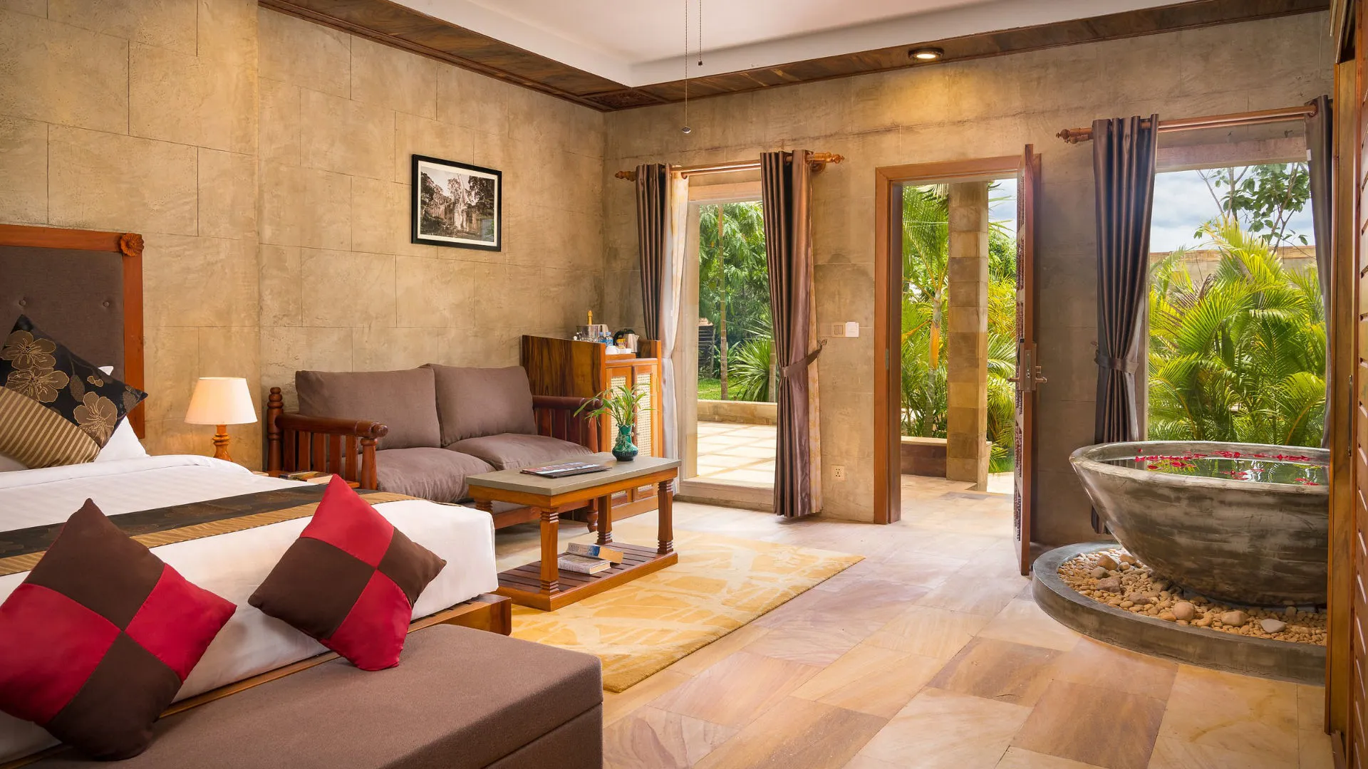 Guest room interior with sofa and outdoor stone soaking tub at Karma Bayon