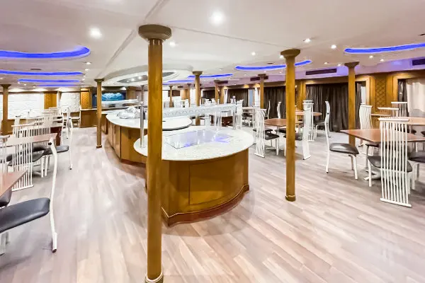 Onboard restaurant with circular buffet and blue mood lighting at Karma Karnak